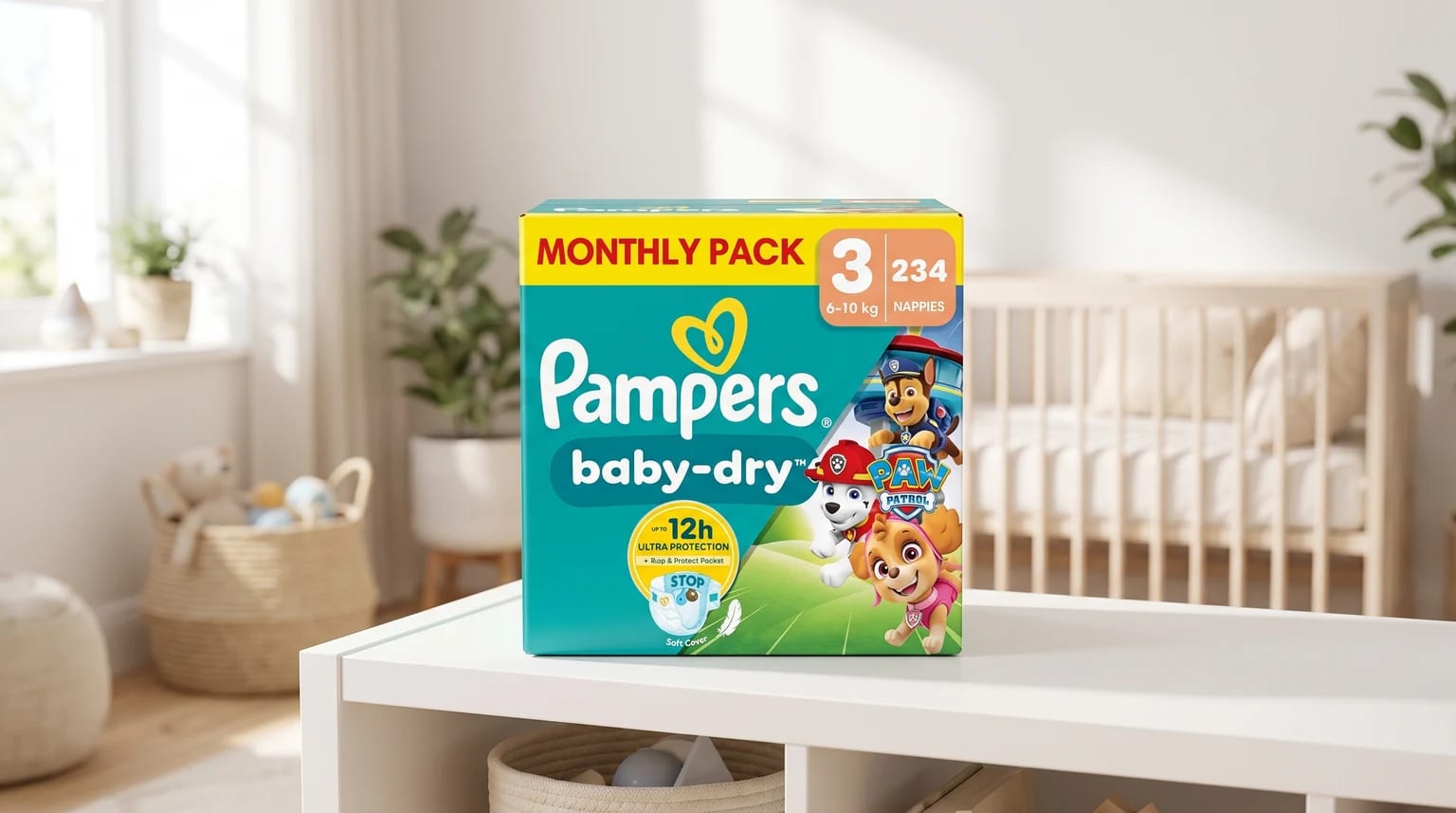 A monthly pack box of Pampers Baby-Dry nappies, featuring Paw Patrol characters, sitting on a white unit in a bright, tidy nursery.