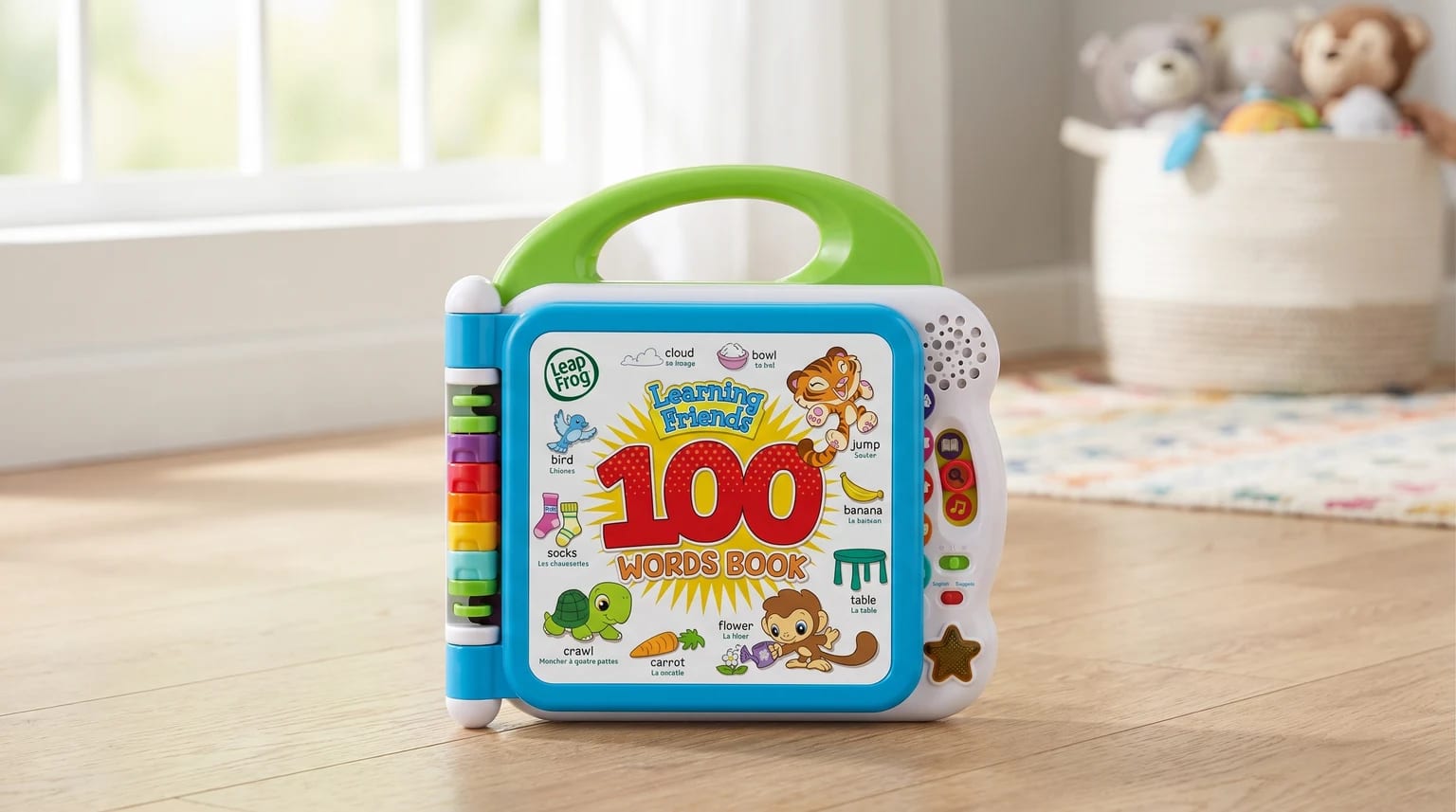 The colourful LeapFrog 100 Words Book, an electronic learning toy, standing on a wooden floor in a child's playroom.