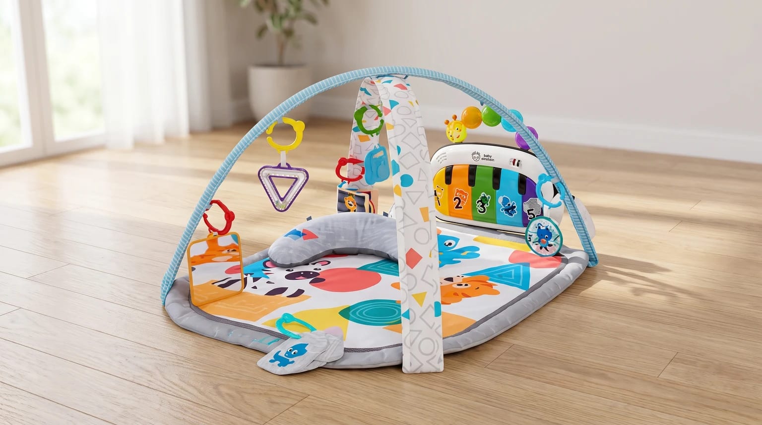 A colourful baby play gym on a wooden floor, featuring an animal-print mat, an arch with hanging toys, and a small piano keyboard.